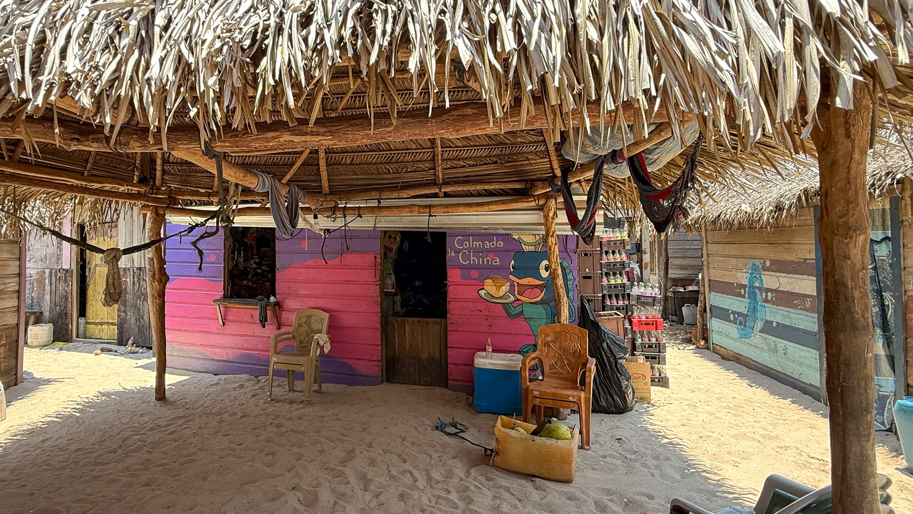 Eine bunt bemalte Huette im Garifuna-Dorf Chachahuate auf den Cayos Cochinos, Honduras