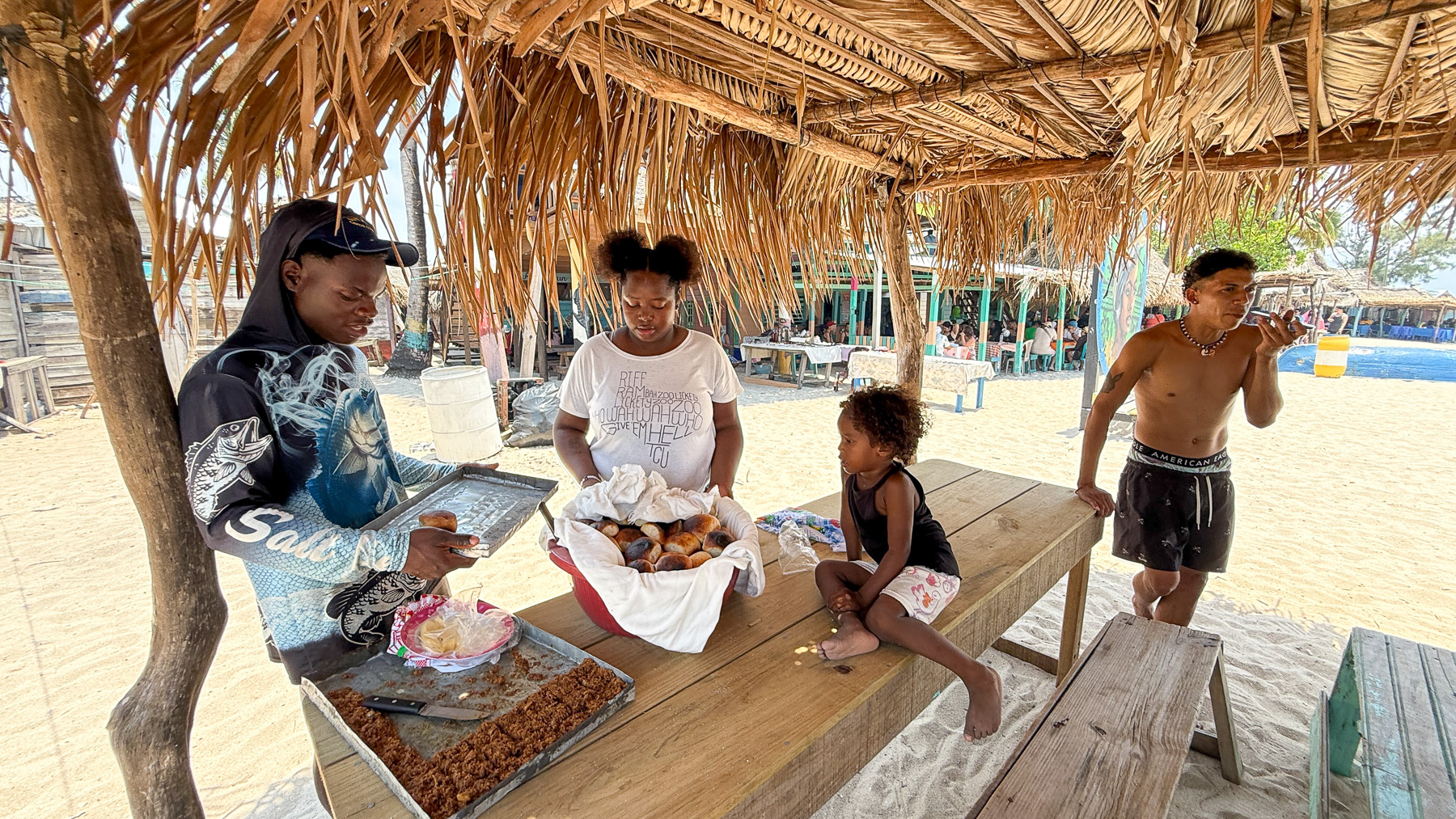 Garifuna füllen frisch gebackenes Brot in Schuesseln zum Verkauf auf Chachahuate, Cayos Cochinos, Honduras